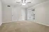 Bright and inviting empty room with plush carpet, ceiling fan, and elegant French doors leading to natural light.