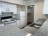 Modern kitchen with sleek countertops, stainless steel sink, and crisp white cabinetry.
