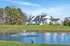 Charming lakeside view featuring a modern apartment complex surrounded by lush greenery and serene waters.