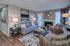 Inviting living room with stylish decor, featuring a cozy gray sofa, modern art pieces, a warm fireplace, and elegant hardwood floors.