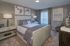 Elegant bedroom featuring a plush bed with stylish pillows, modern artwork, and chic decor in calming neutral tones.