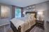 Inviting bedroom with stylish decor, plush bedding featuring elegant patterns, and a serene view from the large window.