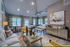 Inviting modern living space with elegant decor, featuring a plush sofa, stylish artwork, and a sunlit dining area enhancing comfort and sophistication.