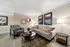 Charming modern living room with stylish gray armchair, elegant sofa, and vibrant artwork, perfect for a cozy and inviting atmosphere.