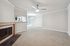 Spacious living room with elegant crown molding, cozy fireplace, and an abundance of natural light.