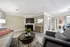 Chic open-plan living area with contemporary furniture, modern kitchen, and ample natural light.