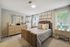 Elegant and cozy bedroom featuring a plush bed, stylish decor, and ample natural light through large windows.