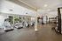 Bright and spacious home gym with modern cardio equipment, free weights, and large windows inviting natural light.