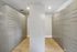 Sleek storage room with modern gray cabinets and elegant wood flooring, ideal for organized urban living.