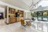 Inviting lounge area with modern seating, chic coffee station, and vibrant pool view through large windows.