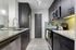 Modern kitchen with sleek black cabinetry, granite countertops, and stainless steel appliances featuring an elegant backsplash and stylish lighting.