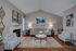 Cozy living room with elegant decor featuring a stylish sofa, accent chairs, contemporary art, and a warm fireplace, ideal for relaxation.