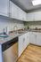 Modern kitchen featuring sleek white cabinetry, stainless steel dishwasher, and elegant granite countertops.