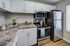 Modern kitchen with sleek stainless steel appliances, elegant white cabinets, and stylish marble countertops, perfect for gourmet cooking.