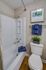 Charming modern bathroom featuring elegant artwork, vibrant blue towels, and rich wood flooring for a cozy touch.
