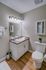 Elegant bathroom featuring modern lighting, granite countertop, and sleek white cabinetry, perfect for a contemporary home.
