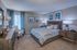 Elegant bedroom with plush bedding, stylish wooden furniture, and soothing blue accents, inviting relaxation and comfort.