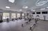 Modern fitness center featuring state-of-the-art cardio equipment, sleek design, and large windows for natural light.