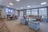 Spacious and modern living room featuring elegant seating, vibrant decor, and floor-to-ceiling windows with scenic views.