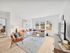 Bright and inviting living room with modern decor, featuring a cozy sectional sofa, stylish armchairs, and large windows letting in natural light.