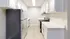 Elegant modern kitchen with sleek white cabinetry, stainless steel appliances, and light wood flooring.