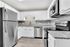 Modern kitchen with sleek stainless steel appliances, elegant white cabinetry, and chic granite countertops, designed for contemporary living.