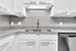 Sleek modern kitchen with granite countertops, stainless steel faucet, and elegant grey subway tile backsplash.