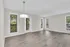 Bright, open living space with elegant flooring and large windows offering lush garden views.