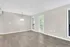 Bright and inviting open-plan living space featuring modern wood flooring, large windows, and patio access for natural light and fresh air.