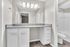 Elegant bathroom featuring a spacious granite countertop, modern lighting, and sleek cabinetry.