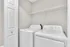 Modern laundry area with sleek white washer and dryer, complemented by a convenient overhead storage shelf.