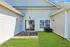 Inviting patio area with modern outdoor seating and lush green lawn, perfect for relaxation and entertaining at home.