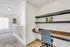 Bright and cozy work-from-home nook with sleek shelves and comfortable chair, perfect for productivity.
