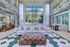 Luxurious lobby with high ceilings, elegant chandelier, and panoramic window view. Features cozy seating, artistic wall decor, and rustic wooden accents.