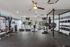 Modern fitness center featuring state-of-the-art equipment, including treadmills, weight racks, and a punching bag, in a bright and inviting space.