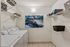 Chic laundry room with stacked washer and dryer, vibrant abstract artwork, and organized shelving for stylish storage solutions.