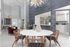 Modern apartment dining area with stylish round table, chic wooden chairs, and contemporary decor under a dazzling chandelier.