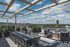 Luxurious rooftop terrace with elegant seating, stunning city views, and charming outdoor string lights under a clear blue sky.