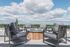Modern rooftop terrace with stylish seating and stunning panoramic views under a bright blue sky.