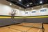 Inviting indoor sports facility with a basketball hoop and versatile court space, perfect for basketball and indoor pickleball games.