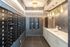 Elegant mailroom with sleek black mailboxes, luxurious marble countertop, and stylish gold pendant lighting.