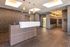 Modern apartment lobby with elegant lighting, sleek reception desk, and stylish black tile flooring.