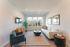Bright and modern living room with sleek furniture, large windows offering city views, and elegant decor.