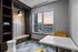 Modern apartment lounge with built-in seating, stylish lighting, and vibrant yellow chairs by a large window showcasing a scenic sunset view.