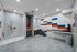 Modern pet grooming room featuring playful patterned walls, a sleek tiled shower area, and bold geometric accents in orange and blue.
