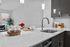 Contemporary kitchen with elegant marble countertops, stylish chrome faucet, and ambient lighting, perfect for modern living.