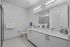 Modern and sleek bathroom design featuring elegant double sinks, spacious countertops, and a stylish walk-in shower.