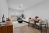 Bright, modern living room with stylish decor, featuring a cozy sofa, elegant dining table, and large windows providing natural light.