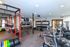 Spacious and modern gym with vibrant equipment, weight racks, and cardio machines, perfect for fitness enthusiasts.