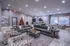 Luxurious living area featuring an elegant sectional sofa, chic patterned armchairs, and modern decor, highlighted by a festive Christmas tree and stylish kitchen bar.